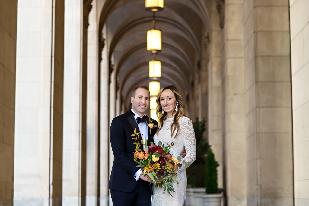 A bride and groom pose in the arches of the Notary Hotel in Philadelphia before their wedding ceremony.